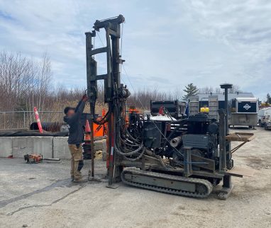 Technicien réalisant un forage de sol dans le cadre d’une étude environnementale Phase II.